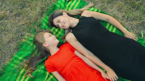 Mother and Daughter Lying on Blanket Outdoors