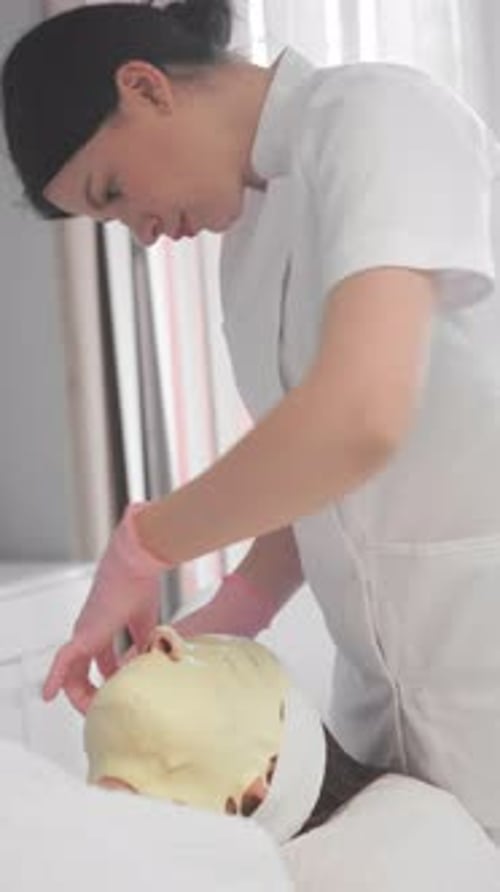 Woman Applying Cream Mask During Cosmetic Procedure
