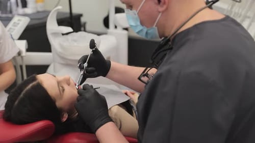 A Dentist is Providing Specialized Treatment to a Patient at a Modern and Contemporary Dental Clinic