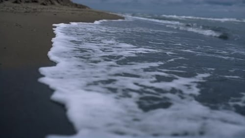 Krachende Wellen stürmen die Strandküste auf der Meereslandschaft. Plätscherndes blaues Meerwasser