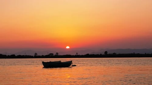 Lone Boat on Water at Stunning Sunset