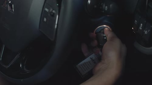 A Darkskinned mans hand puts the key into car ignition and turns on and off Extreme Close up shot