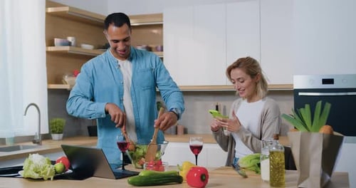 Couple Cooking Salad Together in Bright Kitchen
