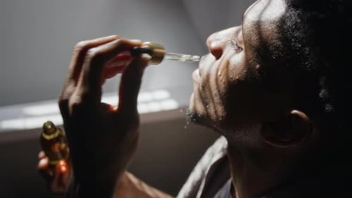 Man Applies Serum to Face in Natural Sunlight