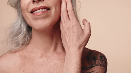 Adult Woman with Gray Hair Touches Face