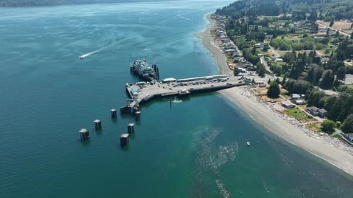 Aerial shot pushing in and titling down towards cars driving off of a public transit ferry.