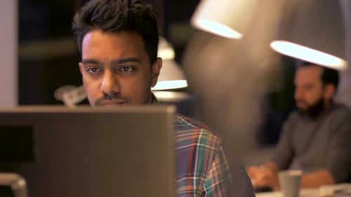 creative man with computer working at night office