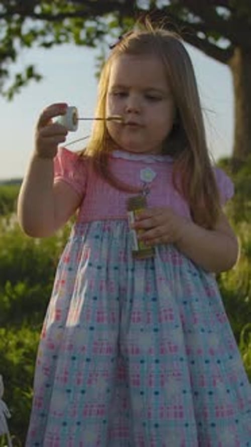 Girl Blowing Bubbles Outdoors on a Sunny Day
