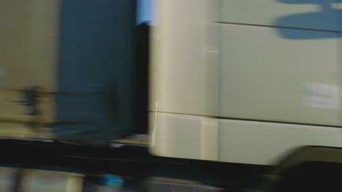 Follow-up Shot of a White Semi Truck with Cargo Trailer Driving Under the Bridge/ Overpass.