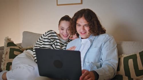 Couple Watching Laptop Together on Couch at Home