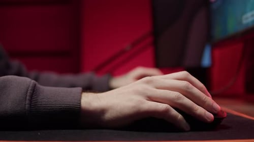 Manos masculinas pulsando botones en el ratón del ordenador, primer plano, jugador que escribe con el teclado retroiluminado, hombre jugando