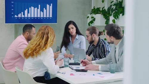Multi Ethnic Coworkers Engaged in Teamwork Gathered in Board Room Working on Collaborative Project