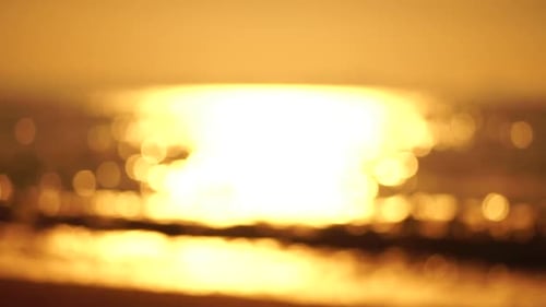 Blurred Golden Sea at Sunset The Sun Reflects and Sparkles on the Waves with Bokeh Illuminating the