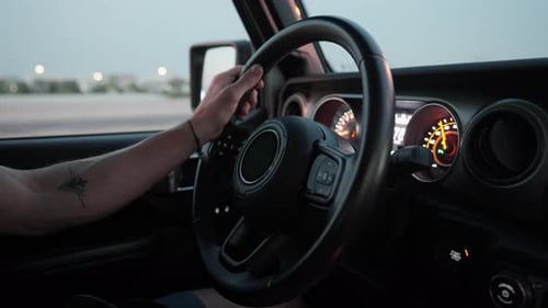 Nahaufnahme der Hand eines Mannes am Lenkrad während der Fahrt