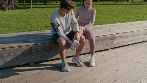 Sportsman Trying to Help Woman with Sprained Ankle while Examining Her Leg