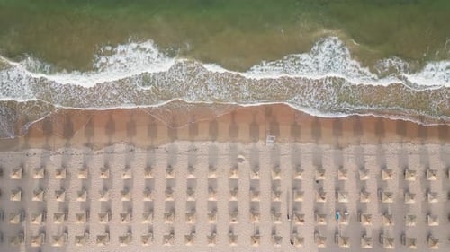 Aerial View of an Amazing Empty Sand Beach with Straw Beach Umbrellas and Turquoise Clear Water