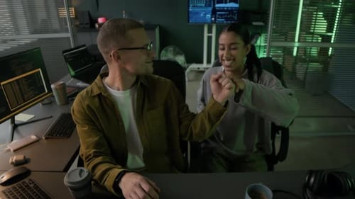 Junger männlicher Programmierer bringt einem jüngeren Kollegen im Büro das Programm Programmieren bei