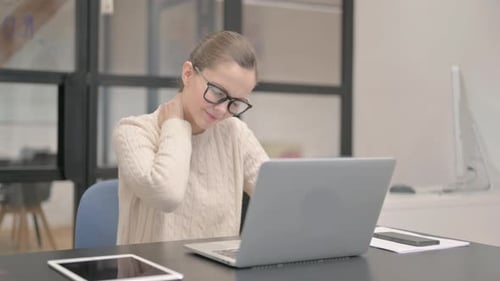 Young Woman having Neck Pain in Office