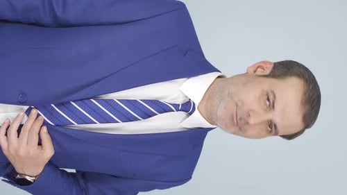 Man in Blue Suit Looks at Camera
