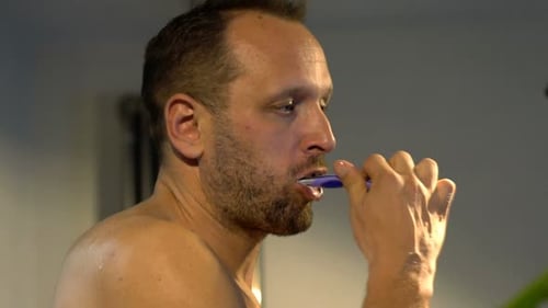Young Man, Brushing Teeth with a Tooth Brush in Bathroom 30s