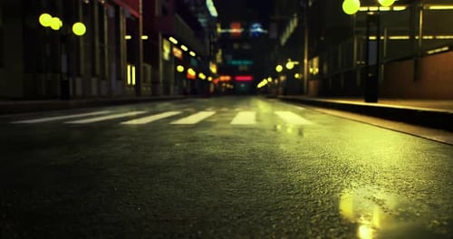 Empty City Street with Wet Pavement and Glowing Streetlights at Night