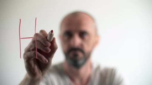 Closeup of a Man Writing on a Glass Board