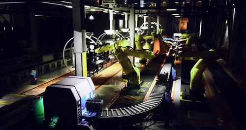Industrial Robots Working on a Production Line During Nighttime Hours
