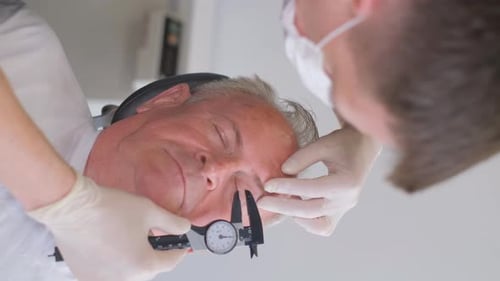 Vertical Video of a Plastic Surgeon Inspecting Sagging Skinand Measuring It with a Caliper