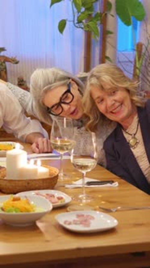 Family Gathering Around Table Taking Photos with Phone