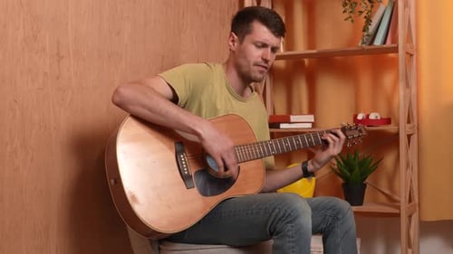 Man Playing Acoustic Guitar and Singing Indoors