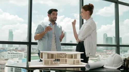 Architects Discussing Building Model in Modern Urban Office