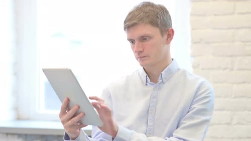 Young Adult Working on a Tablet Indoors