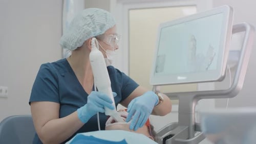 Doctor Scans the Patient's Teeth in the Clinic