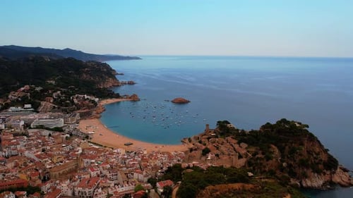 Eine Luftaufnahme von Tossa Del Mar in Spanien, wie es sich vorwärts über die Hügel in die Stadt schlängelt und zeigt