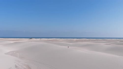 Aerial View of a Solitary Figure Traversing the Expansive Sand Dunes of Socotra Island Yemen Under a