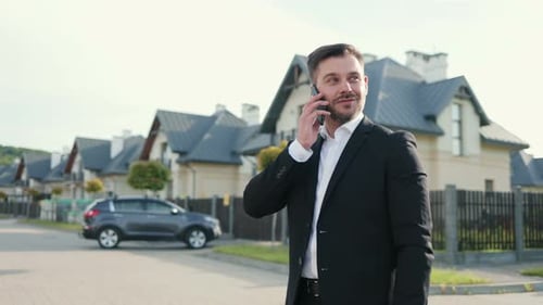 Portrait of Serious Caucasian Male Professional Standing in City and Talking on Smartphone Handsome
