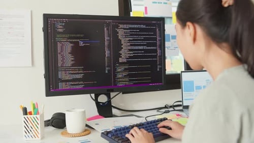 Asia girl IT development programmer typing on keyboard coding programming fixing data code.