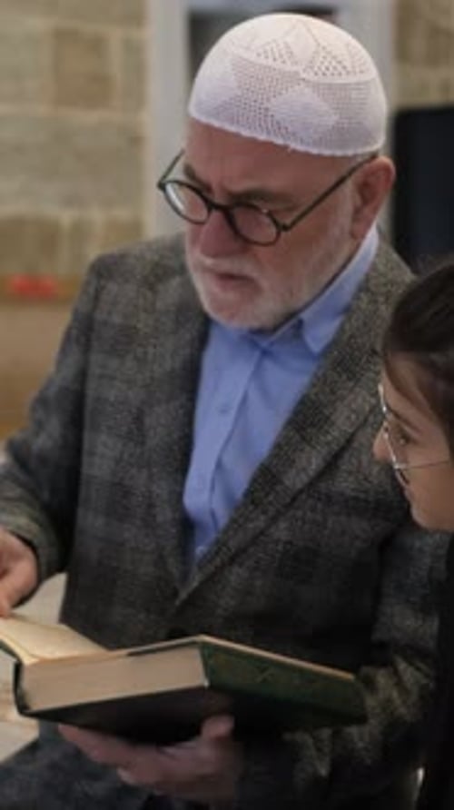 Man Reads Religious Text with a Young Woman