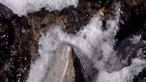 Water flowing in cold river with ice chuncks