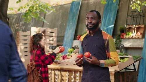 Male Stand Holder with Apron Holding Ripe Bio Produce