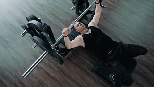 Strong healthy bodybuilder exercising in gym.