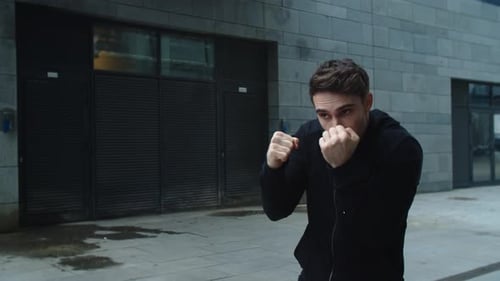Man shadowboxing in urban setting for exercise