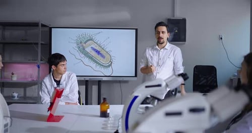 Biologist Teacher Speaking In Classroom Teens Students Of Middle School Listening To Tutor