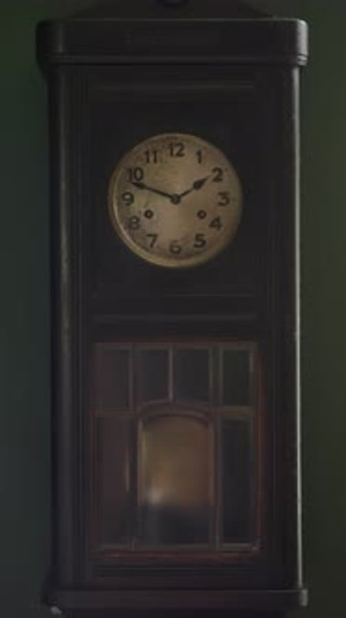 An Old Vintage Clock with the Pendulum Swinging