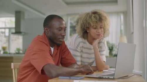 Diverse Couple Using Laptop and Talking at Home