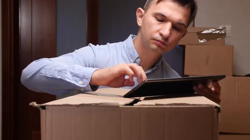 Man Checking Inventory on Tablet During Moving or Delivery