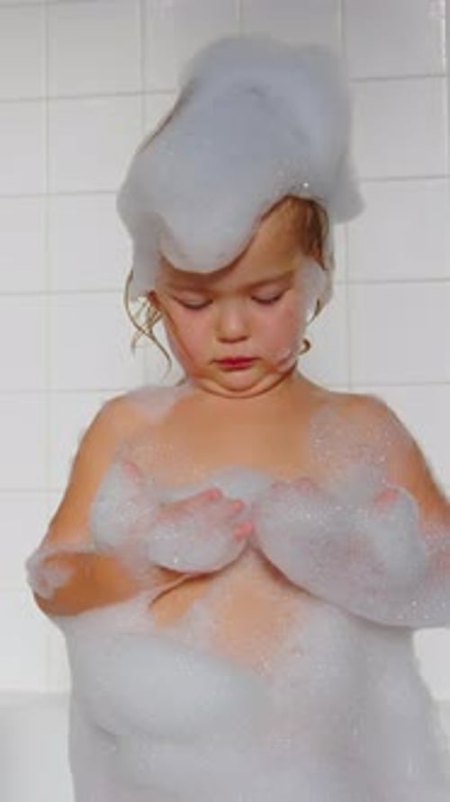 Girl Playing in a Bubble Bath in Bathroom
