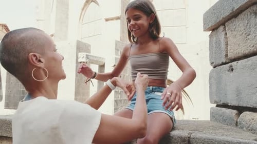 Close-up of mother talks to her daughter against the backdrop of a historic building