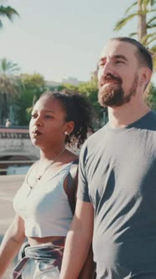 Interracial couple walks down the street holding hands