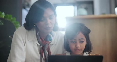 Woman and Child Looking at a Tablet Together